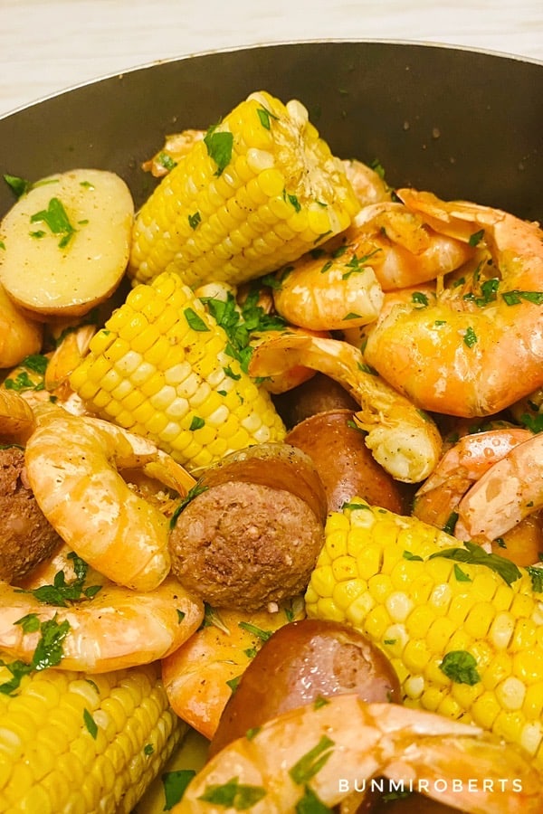 Picture of shrimps, corn, potatoes and sausages with parslley leaves