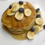 Banana pancake served with slice banana and blueberries and maple syrup