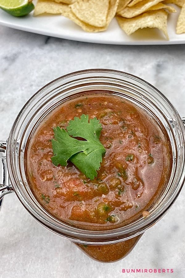 salsa in a glass jar with cilantro in the middle