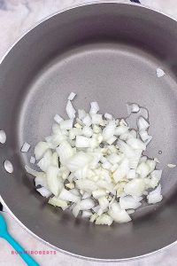 olive oil, garlic and onions being sautéed in a saucepan